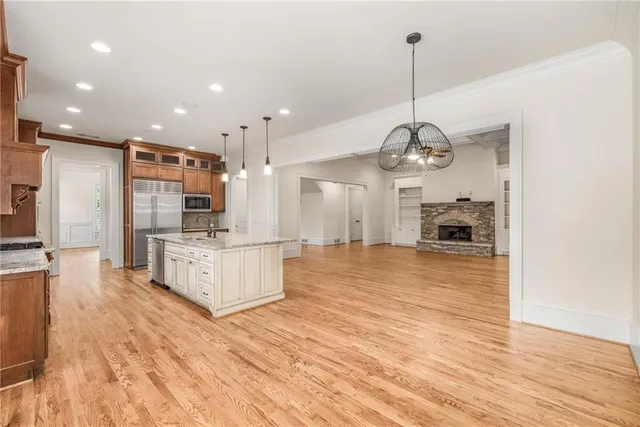 a large kitchen with stainless steel appliances granite countertop a large stove a sink dishwasher and a refrigerator with wooden floor