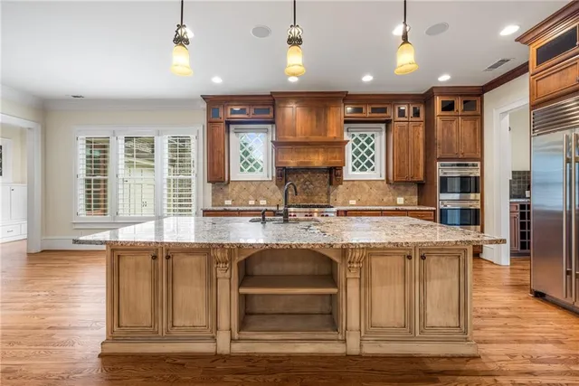 a kitchen with stainless steel appliances granite countertop a stove and a white cabinets