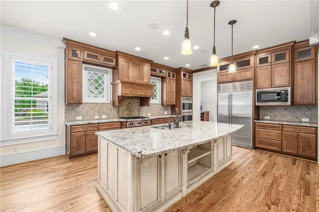 a kitchen with stainless steel appliances granite countertop a sink a stove and a wooden floors