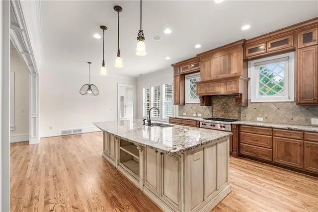 a large white kitchen with granite countertop a refrigerator and a stove top oven