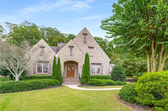 a front view of a house with a yard and trees