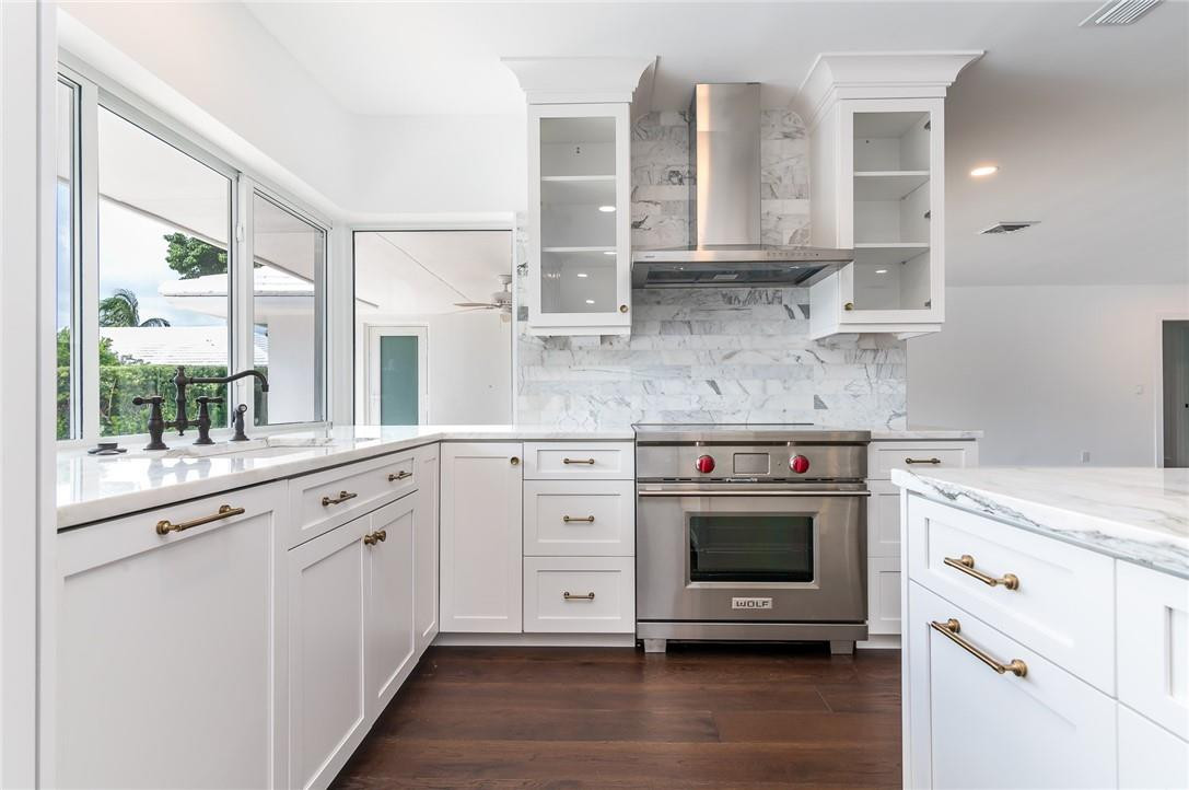 831 Hickory Terrace Boca Raton, FL 33486 - Photo 11 of 25 a kitchen with stainless steel appliances granite countertop a stove a sink and a microwave