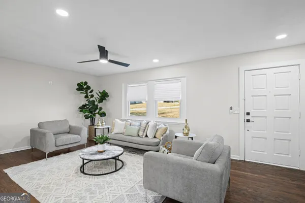 a living room with furniture potted plant and white walls