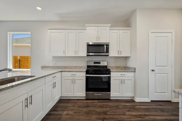 a kitchen with stainless steel appliances granite countertop a stove and a sink