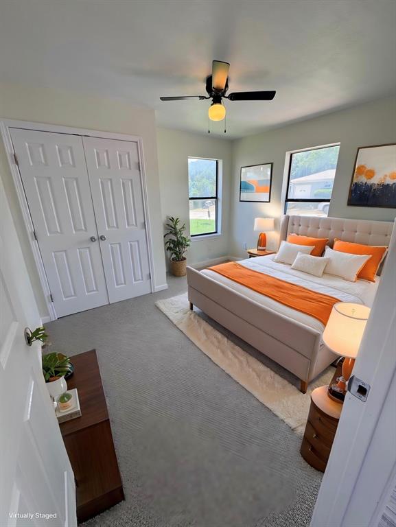 1736 Ransom Terrace Fort Worth, TX 76112 - Photo 17 of 27 Carpeted third bedroom featuring a ceiling fan, two windows with exterior views, and a closet with double panel doors