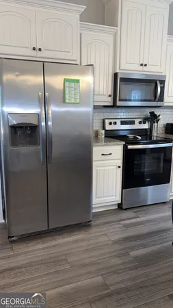 a kitchen with stainless steel appliances a stove a microwave and a hard wood floors