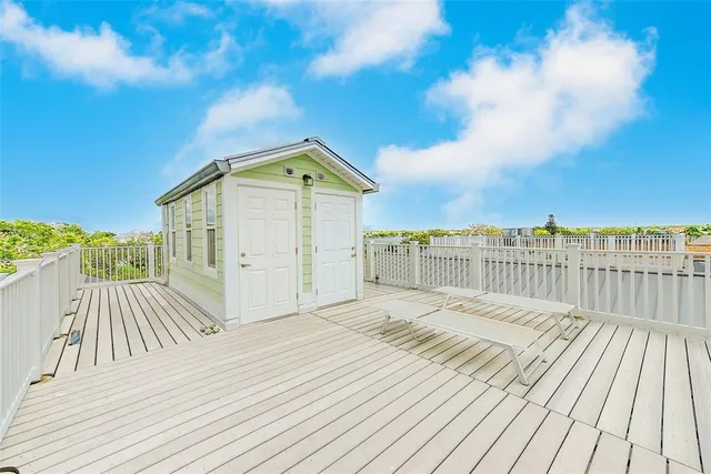 a balcony with wooden floor and iron fence