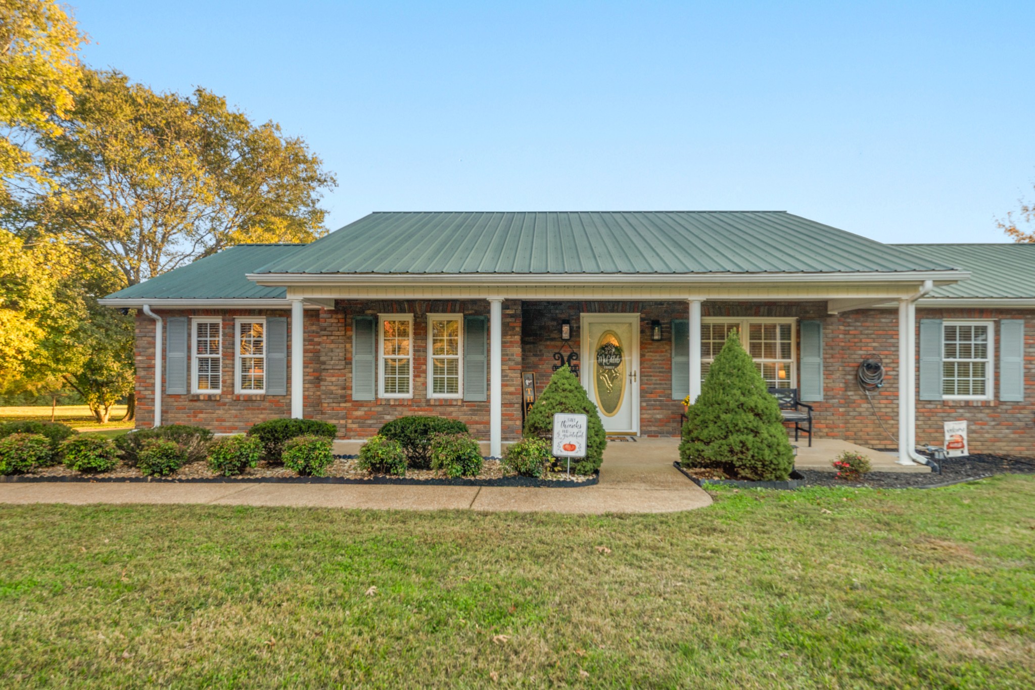 a front view of a house with a porch and outdoor seating