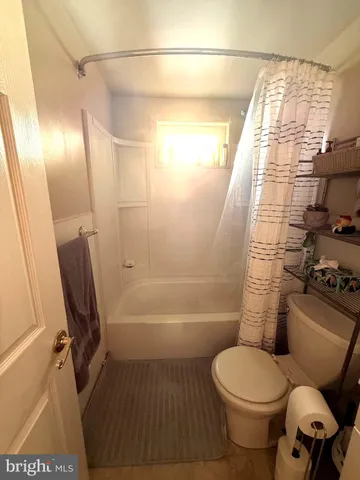 a living room with furniture a flat screen tv and a window