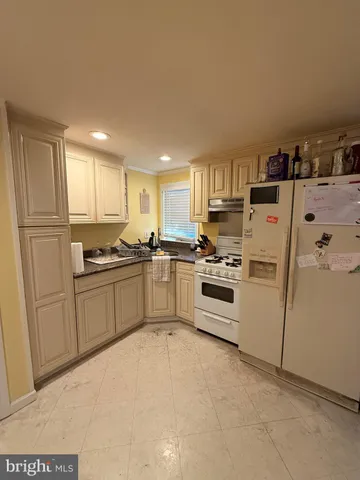 a kitchen with white cabinets and white appliances