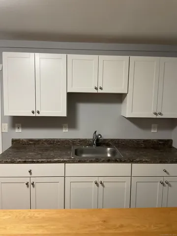 a kitchen with stainless steel appliances granite countertop white cabinets and a granite counter tops
