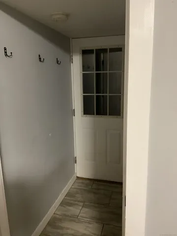 a view of an empty room with wooden floor and windows