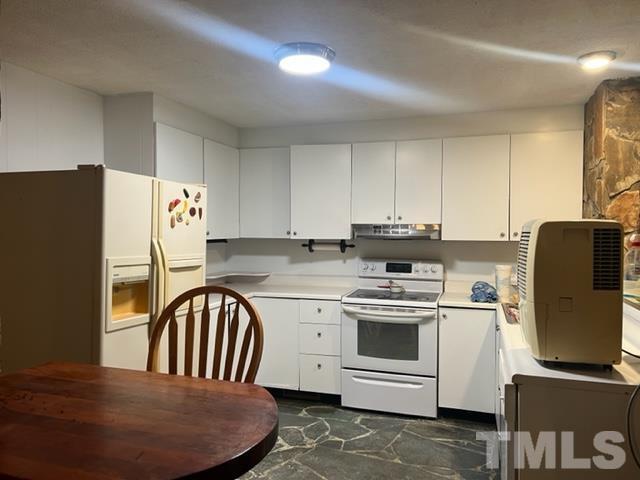 3041 Soapstone Mountain Road Staley, NC 27355 - Photo 14 of 22 a kitchen with stainless steel appliances granite countertop a stove a refrigerator a sink a stove and white cabinets with wooden floor
