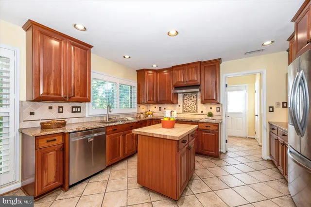 a kitchen with stainless steel appliances granite countertop wooden cabinets a sink and a stove