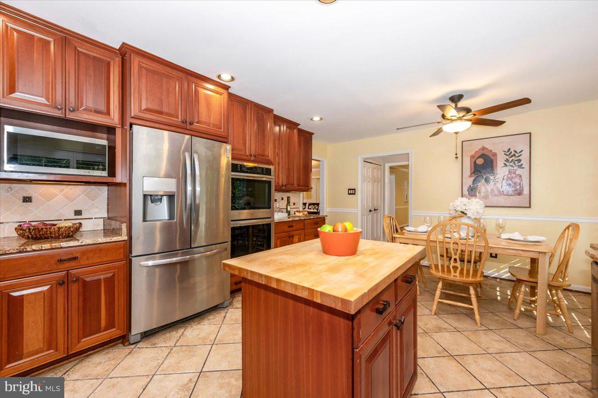10 Megans Court Olney, MD 20832 - Photo 15 of 47 a kitchen with granite countertop a table chairs stove and refrigerator