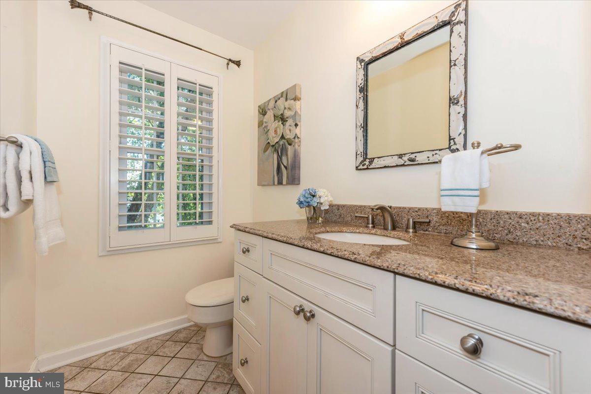 10 Megans Court Olney, MD 20832 - Photo 18 of 47 a bathroom with a granite countertop toilet a sink and a mirror