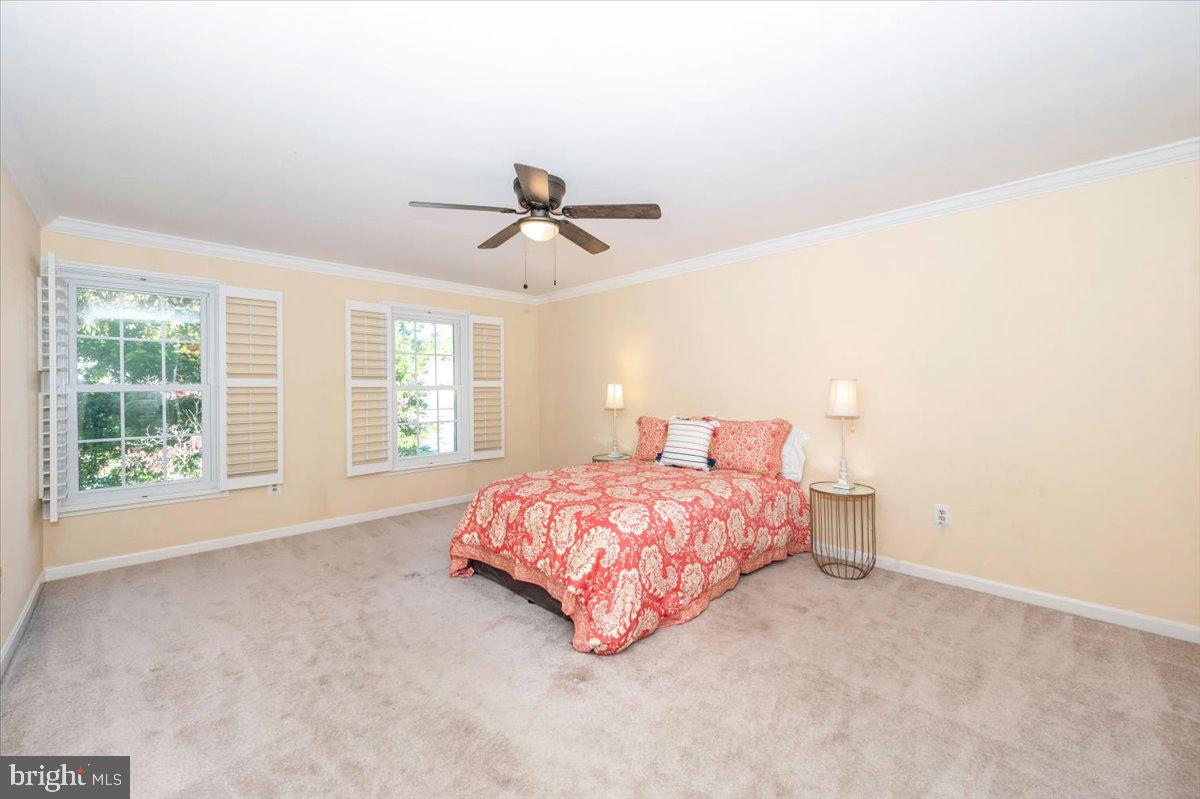 10 Megans Court Olney, MD 20832 - Photo 20 of 47 a spacious bedroom with a bed a window and a chandelier