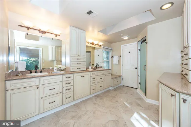 a spacious bathroom with a granite countertop sink mirror and a shower