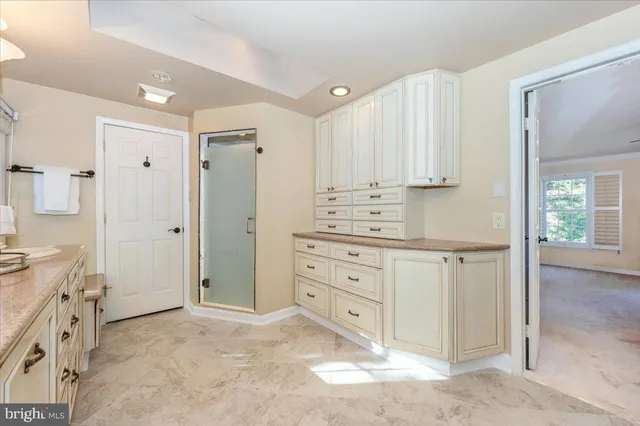 a spacious bathroom with a granite countertop sink mirror and a bathtub