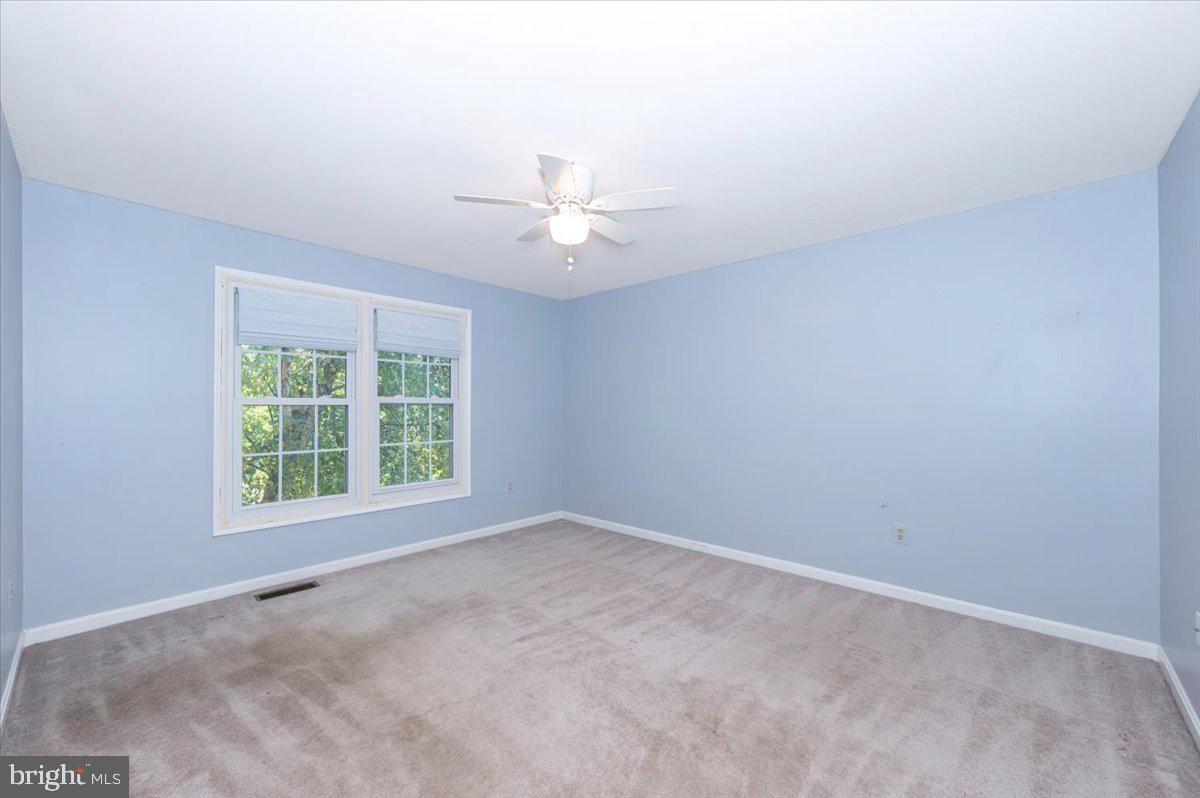 10 Megans Court Olney, MD 20832 - Photo 26 of 47 an empty room with a window and a ceiling fan