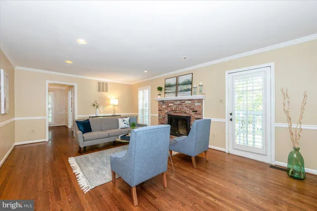a living room with fireplace furniture and a wooden floor