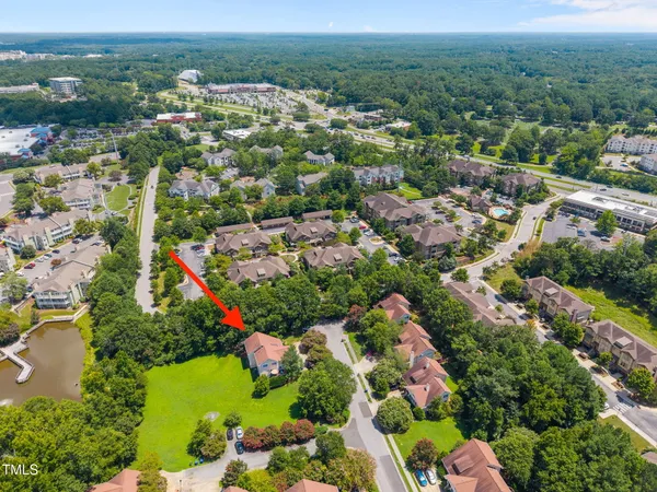an aerial view of residential houses with outdoor space and trees