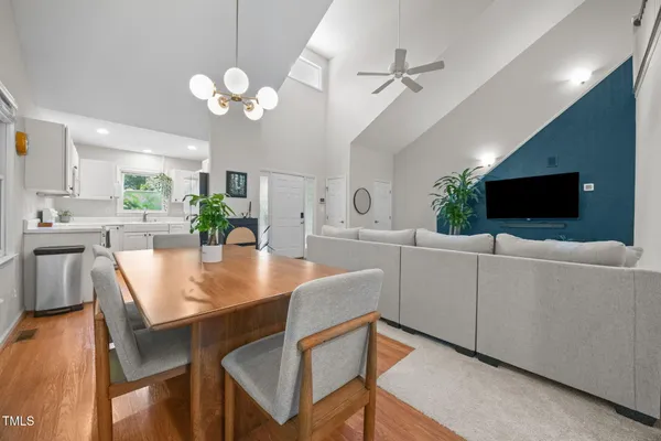 a living room with furniture a flat screen tv and kitchen view