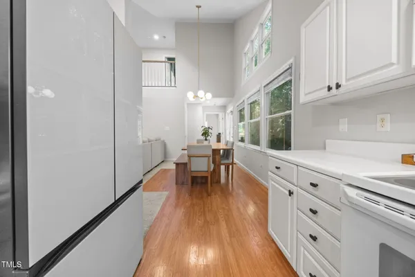 a kitchen with white cabinets and wooden floor