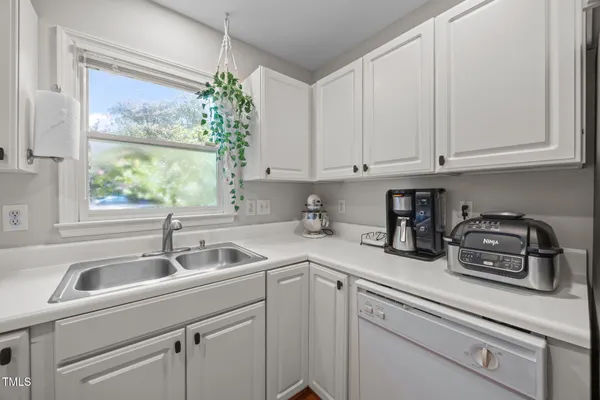 a kitchen with stainless steel appliances granite countertop a sink a refrigerator and cabinets