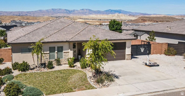 6248 South Daydream Way St. George, UT 84790 - Photo 1 of 1 Ranch-style home featuring an attached garage, stone siding, concrete driveway, a tile roof, and stucco siding