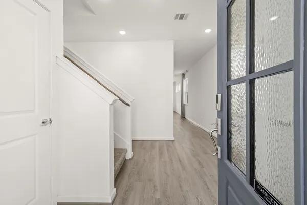 a view of hallway with stairs and wooden floor
