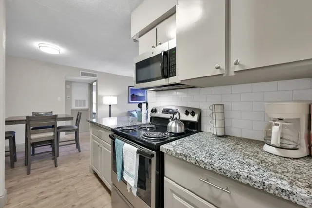 a kitchen with stainless steel appliances granite countertop a sink stove and cabinets