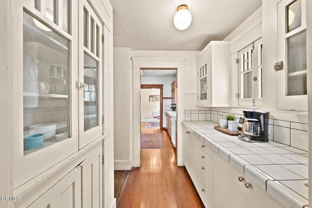 a kitchen with a sink and wooden floor