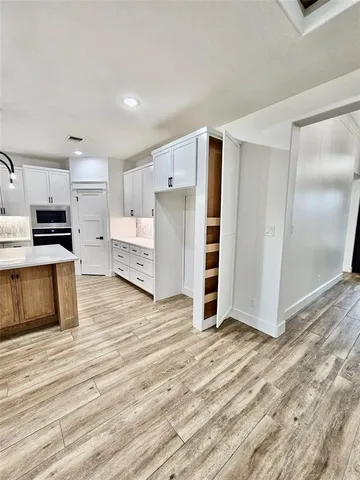 a view of kitchen with wooden floor and electronic appliances