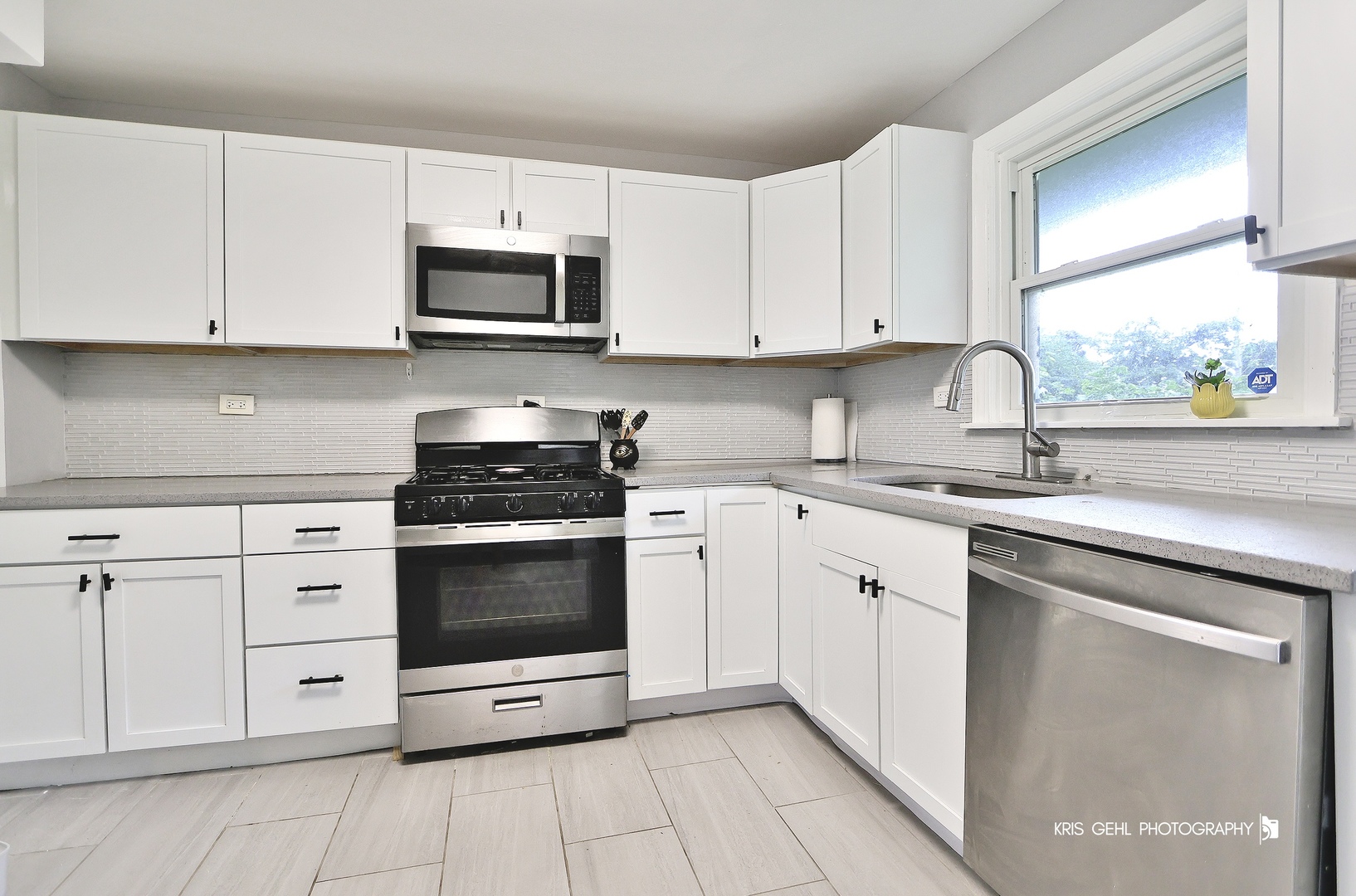 1000 Pine Street Waukegan, IL 60085 - Photo 4 of 13 a kitchen with white cabinets and appliances