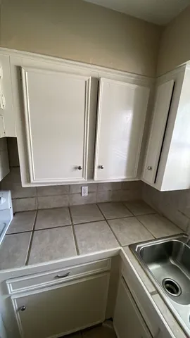 a kitchen with a stove and white cabinets