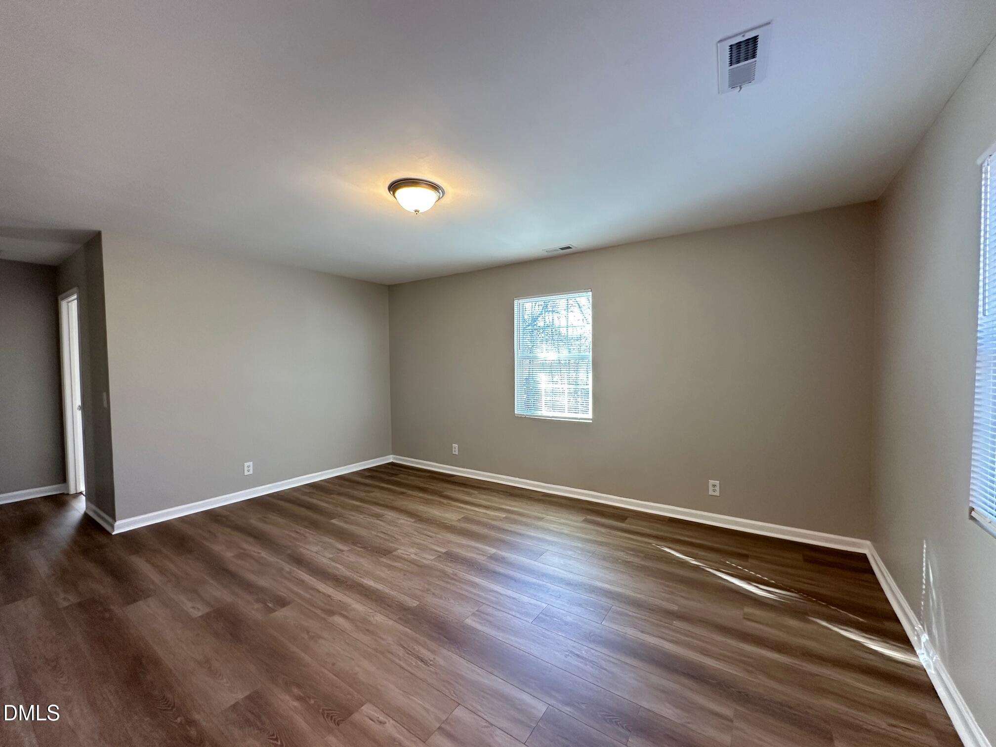 1304 Seabrook Road Raleigh, NC 27610 - Photo 8 of 19 an empty room with wooden floor and windows