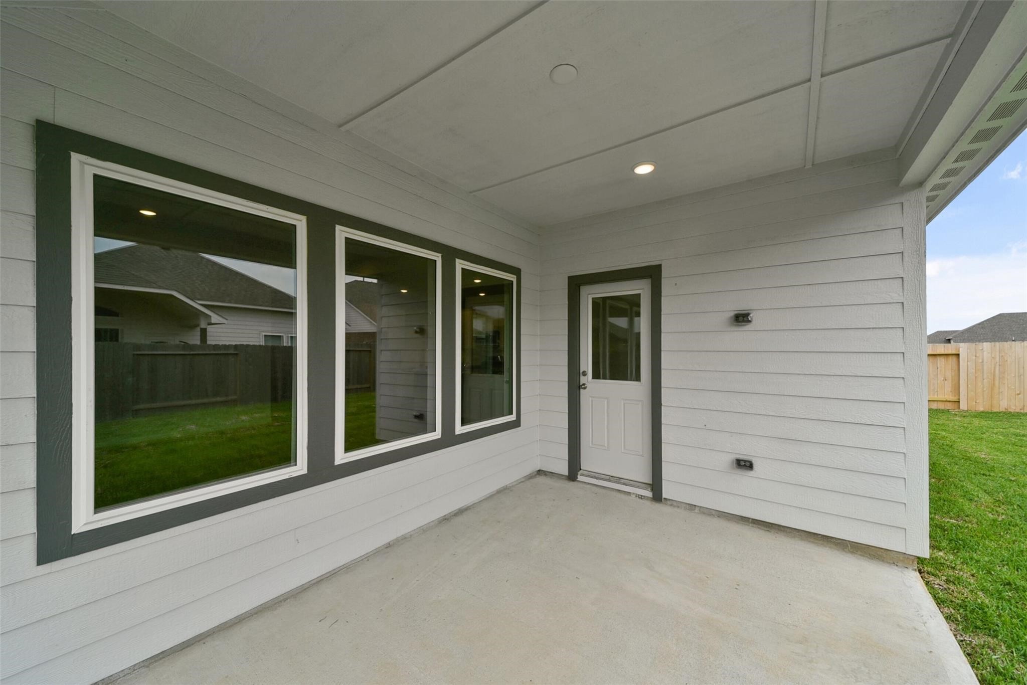 10522 Plumas Run Drive Rosharon, TX 77583 - Photo 27 of 29 Cozy covered patio featuring light gray siding, large windows, and direct access to a grassy backyard—perfect for relaxing or entertaining.
