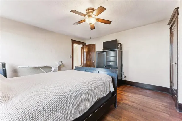 a bedroom with bed and wooden floor
