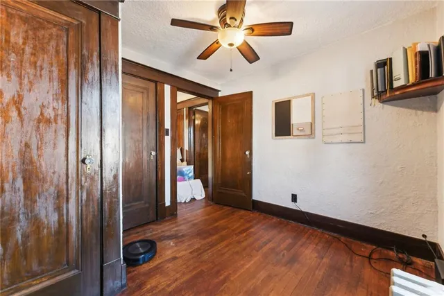 a view of a livingroom with wooden floor and a ceiling fan