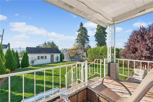 a view of a deck with a floor to ceiling window and wooden fence