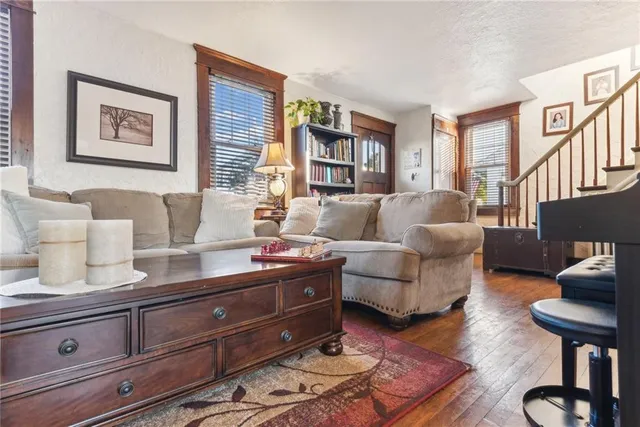 a living room with furniture a bookshelf and a window