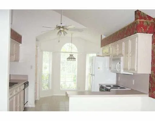 a kitchen that has a lot of windows and refrigerator