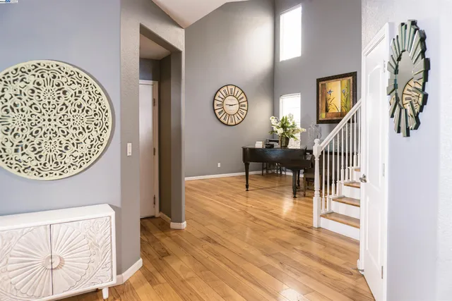 a view of a hallway with wooden floor and a chandelier