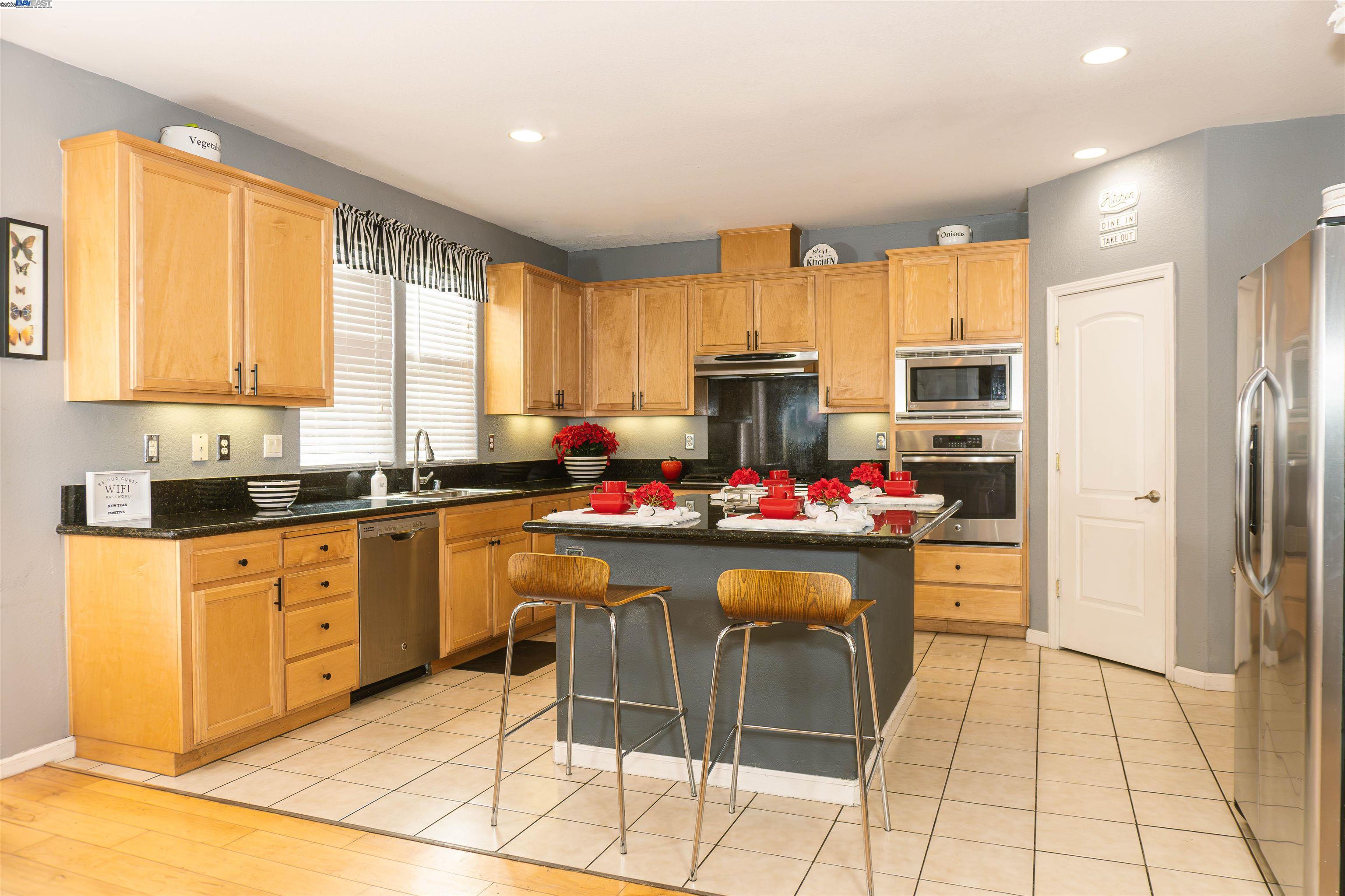 7064 Alder Creek Road Vallejo, CA 94591 - Photo 10 of 14 a kitchen with a refrigerator and a stove top open