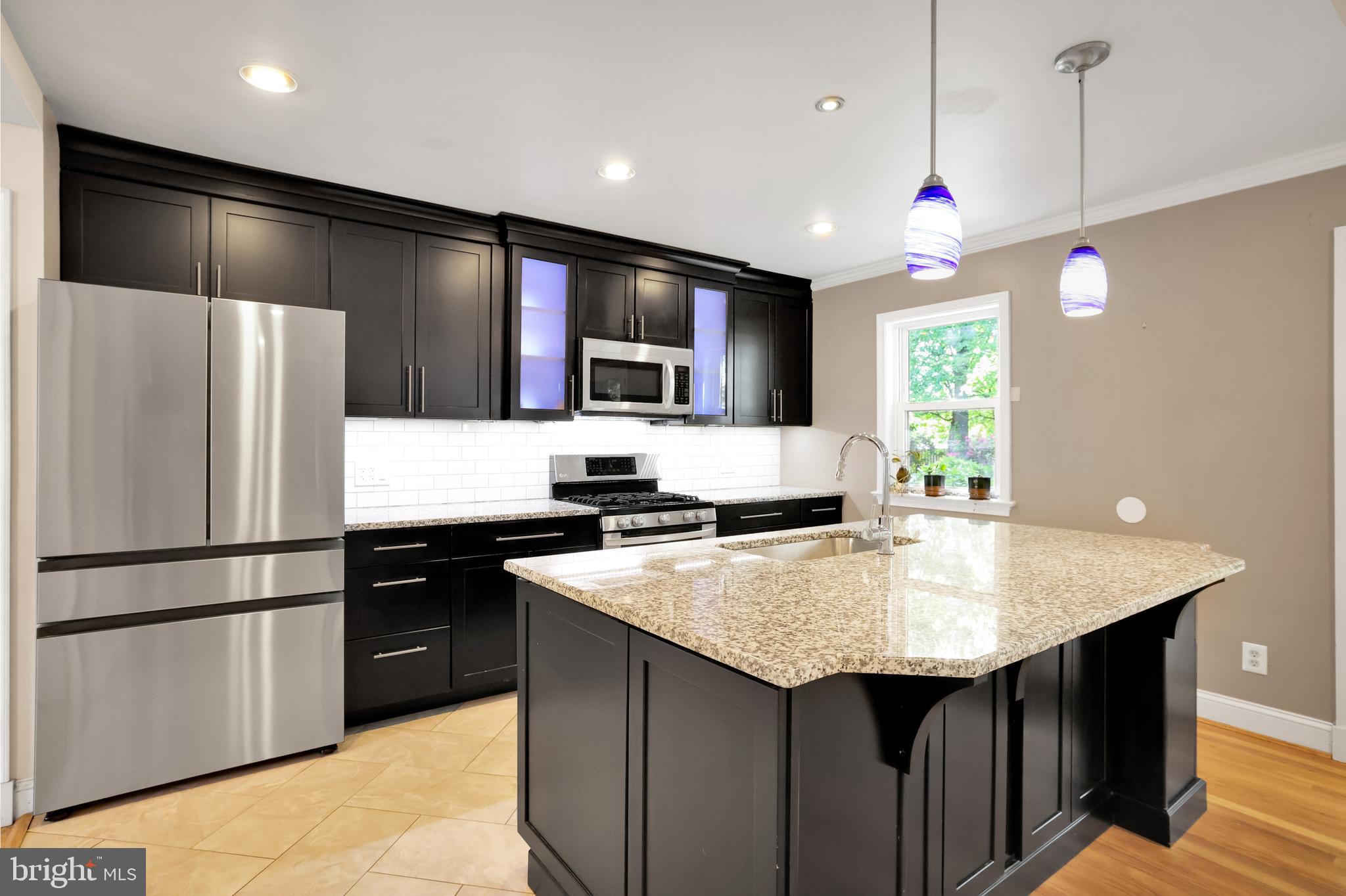 5807 Carlyle Street Cheverly, MD 20785 - Photo 26 of 58 a kitchen with kitchen island a counter space a sink and a refrigerator