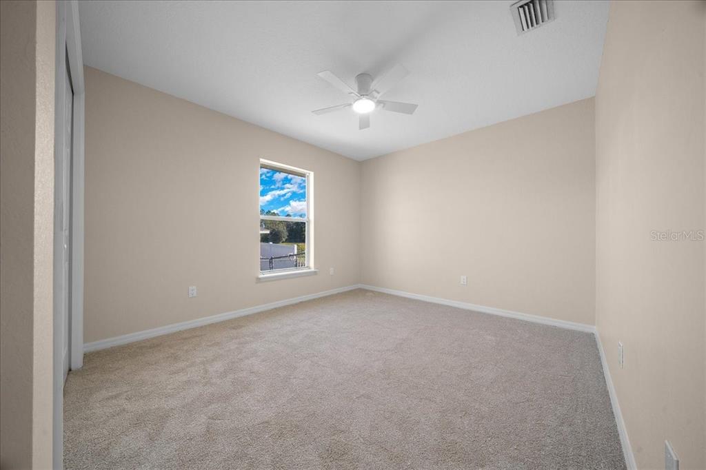 12205 Southeast 100th Court Belleview, FL 34420 - Photo 26 of 73 an empty room with windows and fan