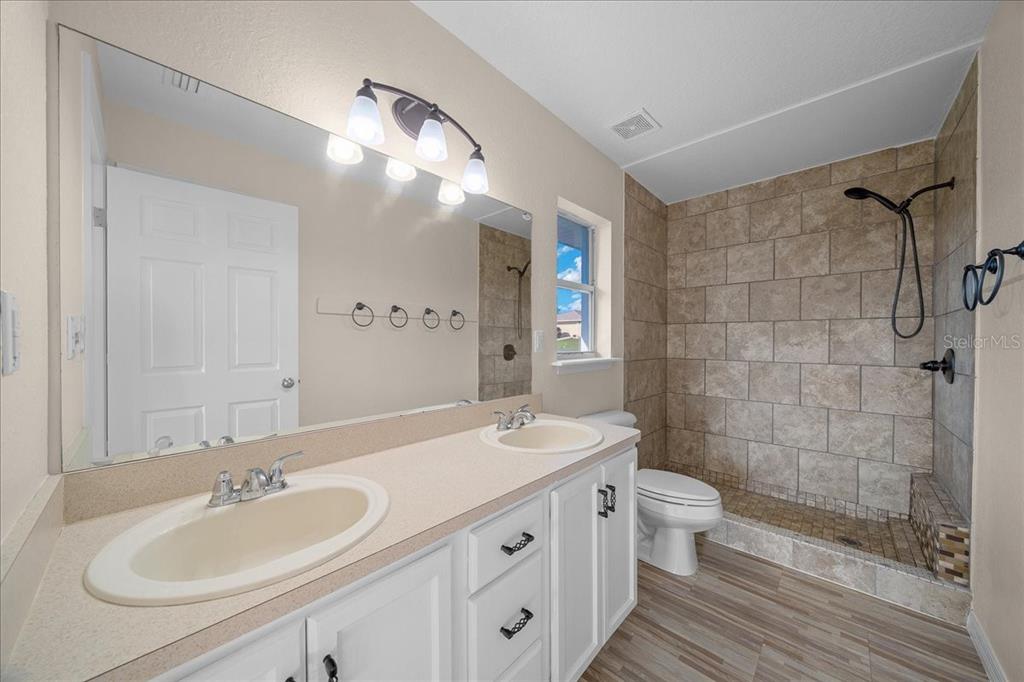 12205 Southeast 100th Court Belleview, FL 34420 - Photo 31 of 73 a bathroom with a double vanity sink mirror and toilet