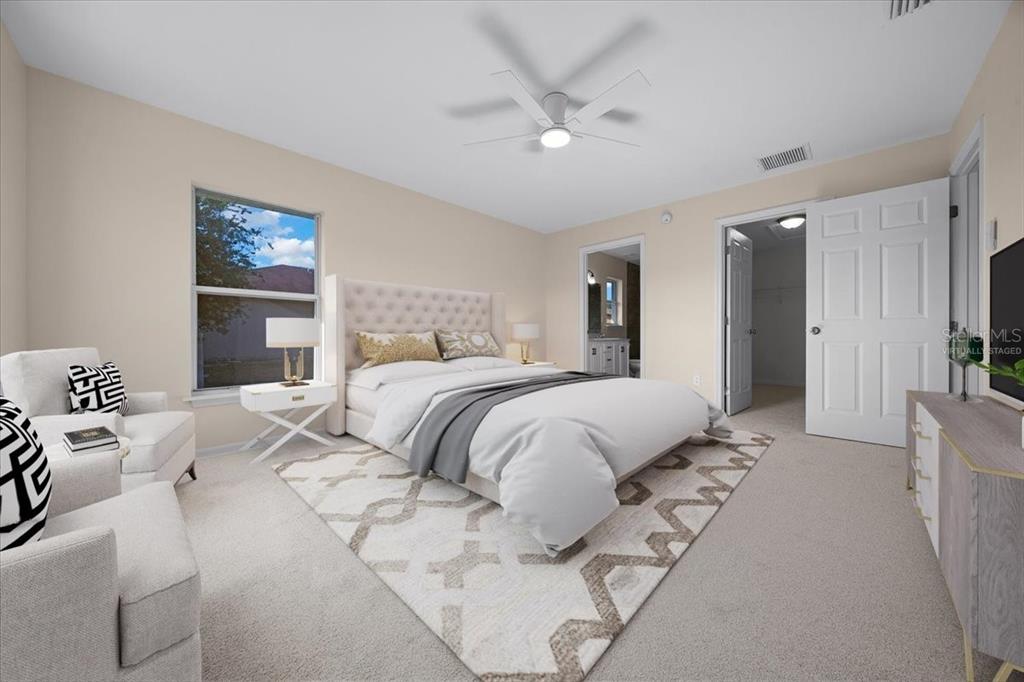 12205 Southeast 100th Court Belleview, FL 34420 - Photo 34 of 73 a bedroom with a large bed and a chandelier