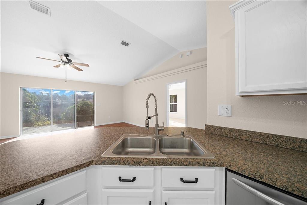 12205 Southeast 100th Court Belleview, FL 34420 - Photo 39 of 73 a kitchen with granite countertop white cabinets and a sink